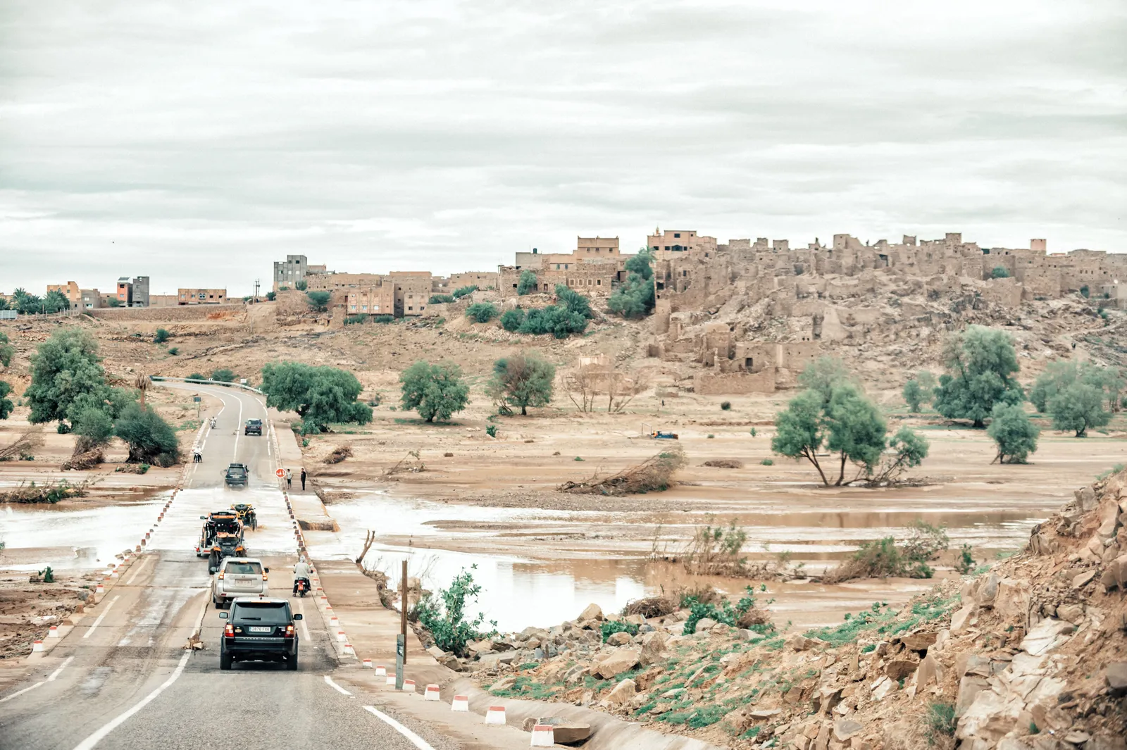 Convoy de 4x4 cruzando un vado inundado junto a un pueblo bereber del valle del Draa