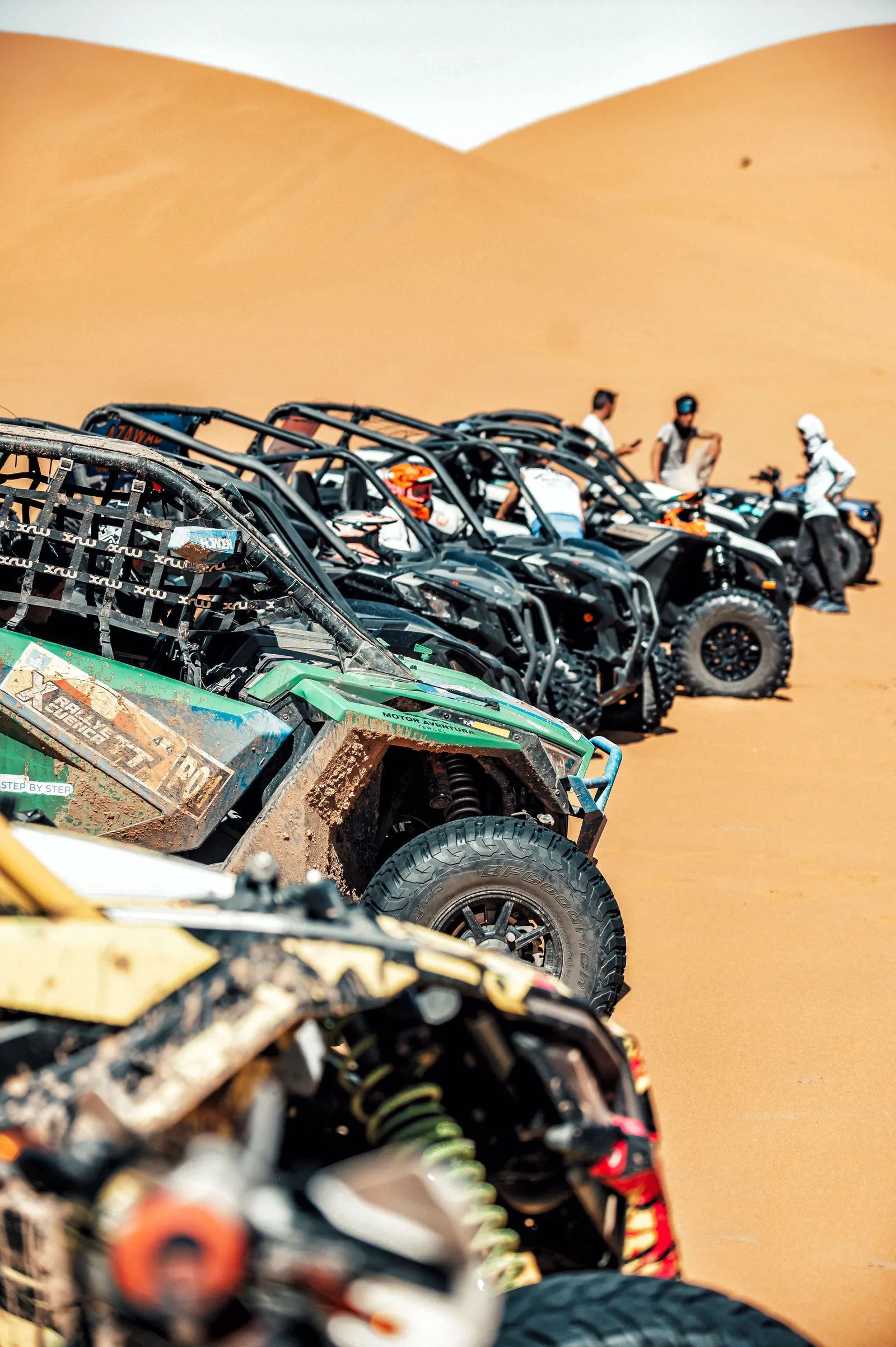Fila de buggys SSV aparcados sobre una duna de arena durante una excursión por el desierto de Marruecos